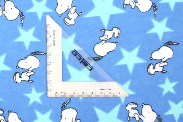 Jumping Snoopy Over Stars on Printed Blue Flannelette